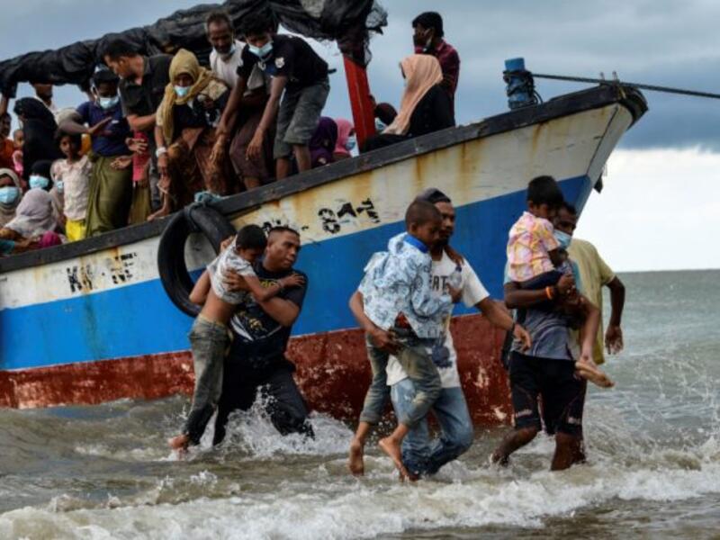 Acehnesse fishermen help evacuate Rohingya children from Myanmar onto the shorelines of Lancok village, in Indonesia's North Aceh Regency on June 25, 2020. - Nearly 100 Rohingya from Myanmar, including 30 children, have been rescued from a rickety wooden boat off the coast of Indonesia's Sumatra island, a maritime official said. (Photo by CHAIDEER MAHYUDDIN / AFP)