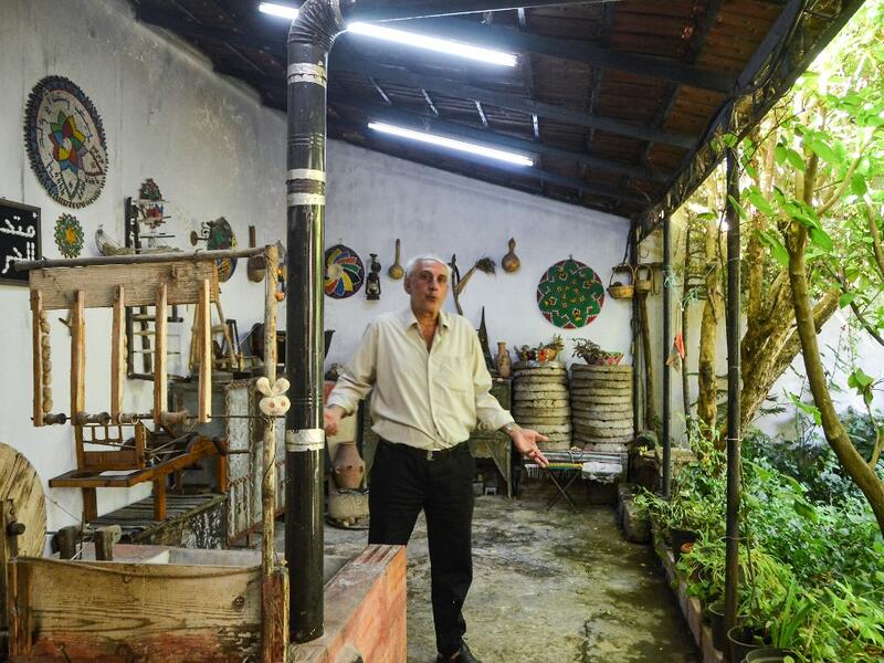 Muhammad Saud, a 65-year-old Syrian silk farmer, handweaves silk threads on a loom at his home workshop in the village of Deir Mama, in west-central Syria on June 22, 2020. MAHER AL MOUNES / AFP