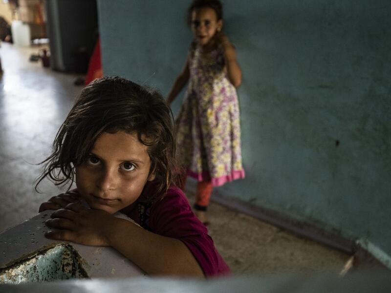 A girl looks on in the stairwell of a school building where Syrians -- displaced from the area of Ras al-Ain by the Turkish offensive on the northeast -- are staying in the city of Hasakah, on June 30, 2020. Delil SOULEIMAN / AFP