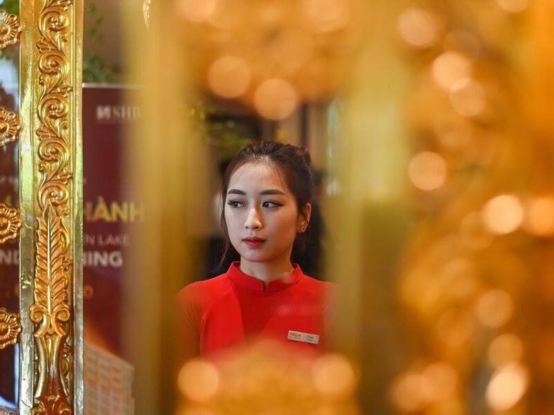 A staff member waits to welcome guests in the lobby of the newly-inaugurated Dolce Hanoi Golden Lake hotel, the world's first gold-plated hotel, in Hanoi on July 2, 2020. Manan VATSYAYANA / AFP