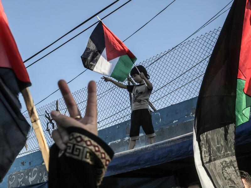 A Palestinian boy waves a national flag during a demonstration against Israel's West Bank annexation plans, in Khan Yunis in the southern Gaza Strip on July 2, 2020. SAID KHATIB / AFP