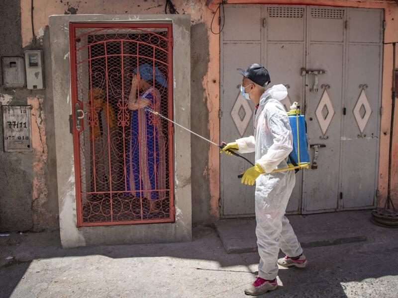 A Moroccan municipal worker disinfects outside a house in a closed street in the southern port city of Safi on June 9, 2020 after Moroccan authorities declared a total lockdown following the discovery of many new COVID-19 coronavirus cases there at a fish canning factory. FADEL SENNA / AFP