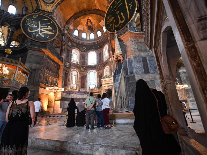 Tourists visit the inside of Hagia Sophia on July 10, 2020, in Istanbul, before a top Turkish court revoked the sixth-century Hagia Sophia's status as a museum, clearing the way for it to be turned back into a mosque. The Council of State, the country's highest administrative court which on July 2 debated a case brought by a Turkish NGO, cancelled a 1934 cabinet decision and ruled the UNESCO World Heritage site would be reopened to Muslim worshipping. The sixth-century Istanbul building -- a magnet for tour