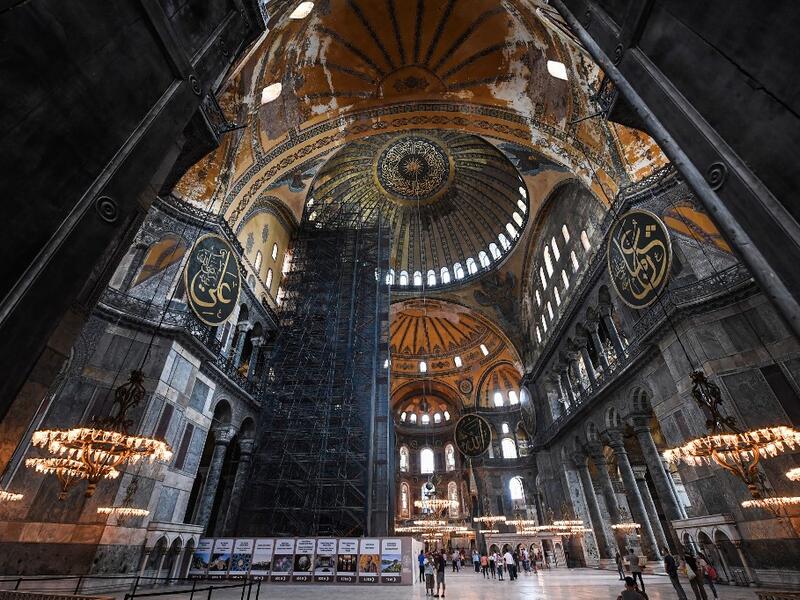 Tourists visit the inside of Hagia Sophia on July 10, 2020, in Istanbul, before a top Turkish court revoked the sixth-century Hagia Sophia's status as a museum, clearing the way for it to be turned back into a mosque. The Council of State, the country's highest administrative court which on July 2 debated a case brought by a Turkish NGO, cancelled a 1934 cabinet decision and ruled the UNESCO World Heritage site would be reopened to Muslim worshipping. The sixth-century Istanbul building -- a magnet for tour