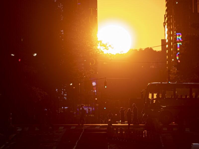 The sun sets along 42nd Street, during the so called "Manhattanhenge", on July 13, 2020 in New York City. The so called Manhattanhenge happens four times each year, when when the sun rises or sets in New York City parallel to the city street grid in Manhattan. Johannes EISELE / AFP