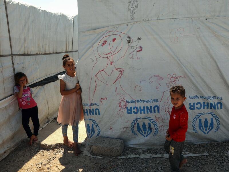 Displaced Iraqi Yazidi children stand next to a tent at a camp in Khanke, a few kilometres from the Turkish border in Iraq's Dohuk province, on June 24, 2019. (AFP / Safin Hamed)