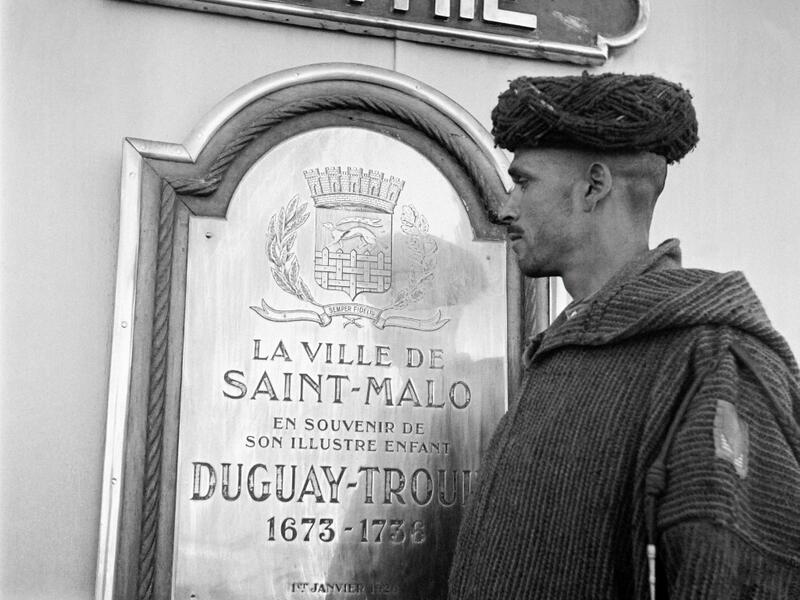 A Moroccan goumier (indigenous Moroccan soldiers who served in the French Army) looks at a commemmorative plate, under a sign where is written "patrie", aboard the French Navy light cruiser Duguay-Trouin in October 1945, before disembarking in the port of Casablanca. AFP