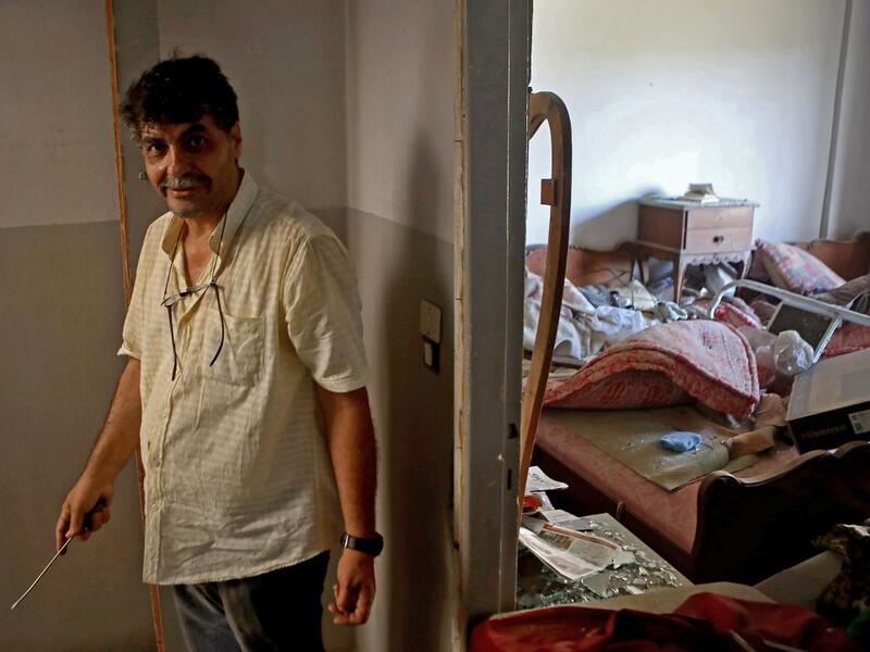 A man stands in his damaged apartment in the damaged neighbourhood of Mar Mikhael in the Lebanese capital Beirut on August 6, 2020, two days after a massive explosion shook the Lebanese capital. The blast, which appeared to have been caused by a fire igniting 2,750 tonnes of ammonium nitrate left unsecured in a warehouse, was felt as far away as Cyprus, some 150 miles (240 kilometres) to the northwest. The scale of the destruction was such that the Lebanese capital resembled the scene of an earthquake, with