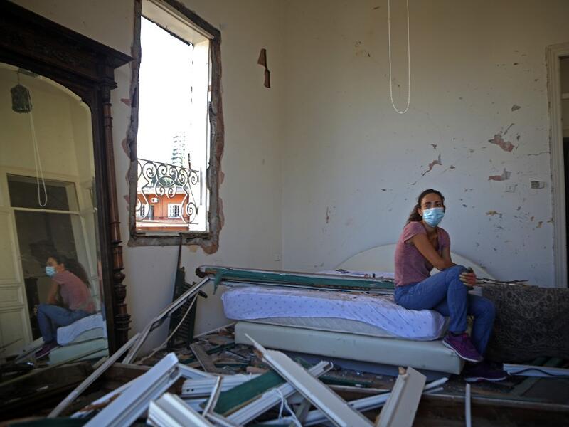 Lebanese dietitian Lama Mattar sits in her damaged bedroom in the damaged neighbourhood of Mar Mikhael in the Lebanese capital Beirut on August 6, 2020, two days after a massive explosion shook the Lebanese capital. The blast, which appeared to have been caused by a fire igniting 2,750 tonnes of ammonium nitrate left unsecured in a warehouse, was felt as far away as Cyprus, some 150 miles (240 kilometres) to the northwest. The scale of the destruction was such that the Lebanese capital resembled the scene o