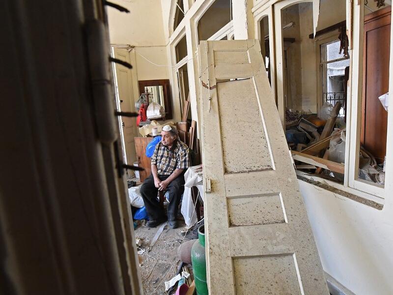 A man sits inside his damaged house in the Lebanese capital Beirut on August 6, 2020, two days after a massive explosion shook the Lebanese capital. The blast, which appeared to have been caused by a fire igniting 2,750 tonnes of ammonium nitrate left unsecured in a warehouse, was felt as far away as Cyprus, some 150 miles (240 kilometres) to the northwest. The scale of the destruction was such that the Lebanese capital resembled the scene of an earthquake, with thousands of people left homeless and thousan