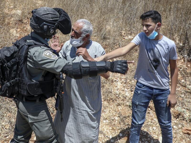A member of Israeli security argues with a Palestinian demonstrator during a rally to protest Israel's plan to annex parts of the occupied West Bank, in the Palestinian village of Haris, southwest of Nablus, on August 7, 2020. JAAFAR ASHTIYEH / AFP