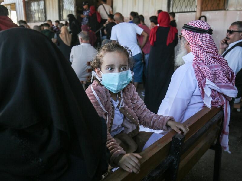 Palestinians wait to cross to the Egyptian side of Rafah border crossing after months of closure due to the coronavirus pandemic in the southern Gaza Strip, on August 11, 2020. SAID KHATIB / AFP