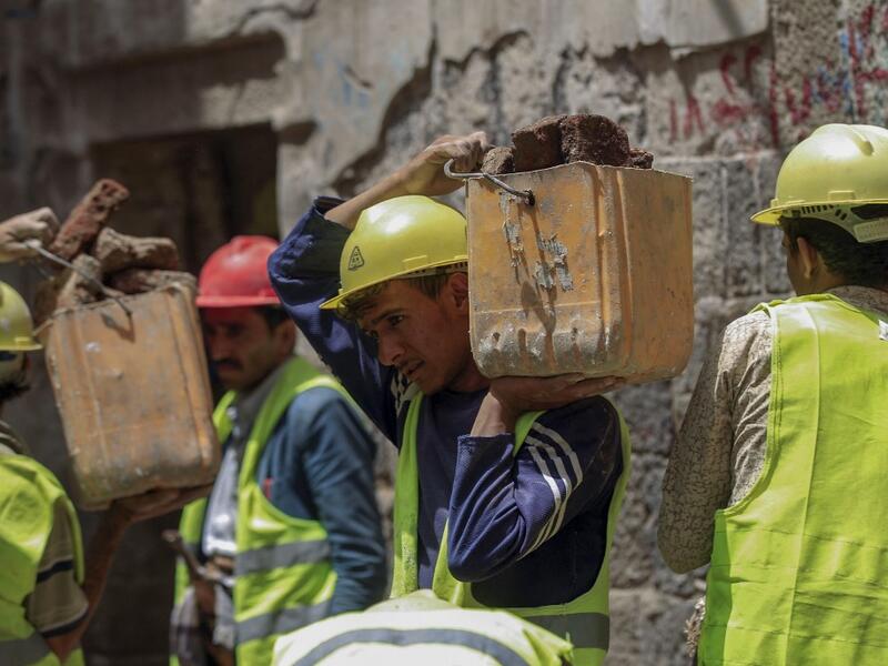 Yemeni labourers remove the rubble ahead of restoration works on the site of a collapsed UNESCO-listed building following heavy rains, in the old city of the Yemeni capital Sanaa, on August 12, 2020. Flash floods triggered by torrential rains have killed at least 172 people across Yemen over the past month, damaging homes and UNESCO-listed world heritage sites, officials said. Mohammed HUWAIS / AFP