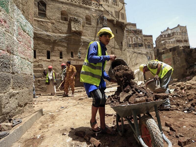 Yemeni labourers remove the rubble ahead of restoration works on the site of a collapsed UNESCO-listed building following heavy rains, in the old city of the Yemeni capital Sanaa, on August 12, 2020. Flash floods triggered by torrential rains have killed at least 172 people across Yemen over the past month, damaging homes and UNESCO-listed world heritage sites, officials said. Mohammed HUWAIS / AFP