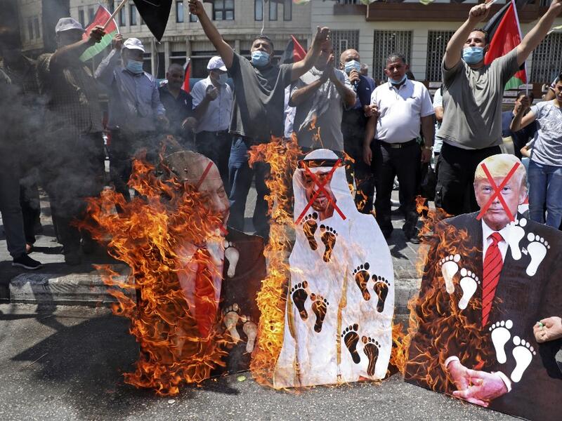 Palestinian protesters set aflame cut-outs showing the faces of (L to R) Israeli Prime Minister Benjamin Netanyahu, Abu Dhabi Crown Prince Sheikh Mohammed bin Zayed al-Nahyan, and US President Donald Trump, during a demonstration in Nablus in the occupied West Bank on August 14, 2020 against a US-brokered deal between Israel and the UAE. AFP