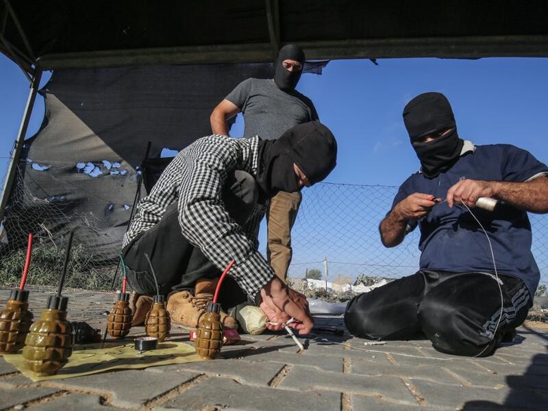 Palestinians prepare incendiary devices before being attached to inflated condoms and plastic bags, to be directed and flown towards Israel, near Rafah along the border between the Gaza Strip and Israel on August 21, 2020. SAID KHATIB / AFP