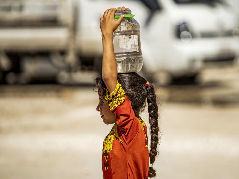 A displaced Syrian brings water back to their camp in a camp for the displaced in Syria's northeastern city of Hasakah on August 24, 2020. Delil SOULEIMAN / AFP