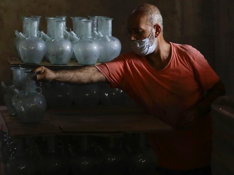 A worker arranges finished jugs at a factory, which is recycling the broken glass as a result of the Beirut explosion, in the northern Lebanese port city of Tripoli on August 25, 2020. The August 4 port explosion ripped through countless glass doors and windows when it laid waste to whole Beirut neighbourhoods, killing at least 190 people and wounding thousands more. Volunteers, non-governmental groups and entrepreneurs salvaged a fraction of the tonnes of broken glass that littered the streets, some of it 