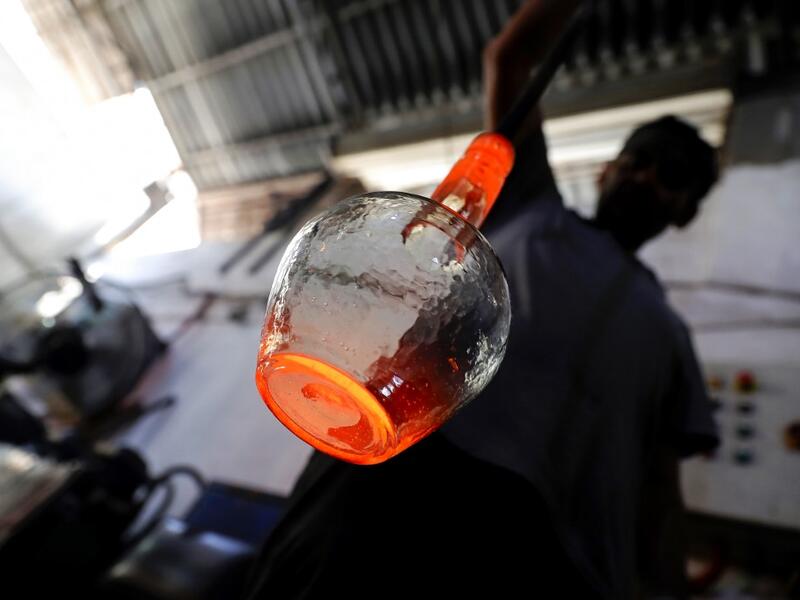 A glassblower forms glass at factory, which is recycling the broken glass as a result of the Beirut explosion, in the northern Lebanese port city of Tripoli on August 25, 2020. The August 4 port explosion ripped through countless glass doors and windows when it laid waste to whole Beirut neighbourhoods, killing at least 190 people and wounding thousands more. Volunteers, non-governmental groups and entrepreneurs salvaged a fraction of the tonnes of broken glass that littered the streets, some of it through 