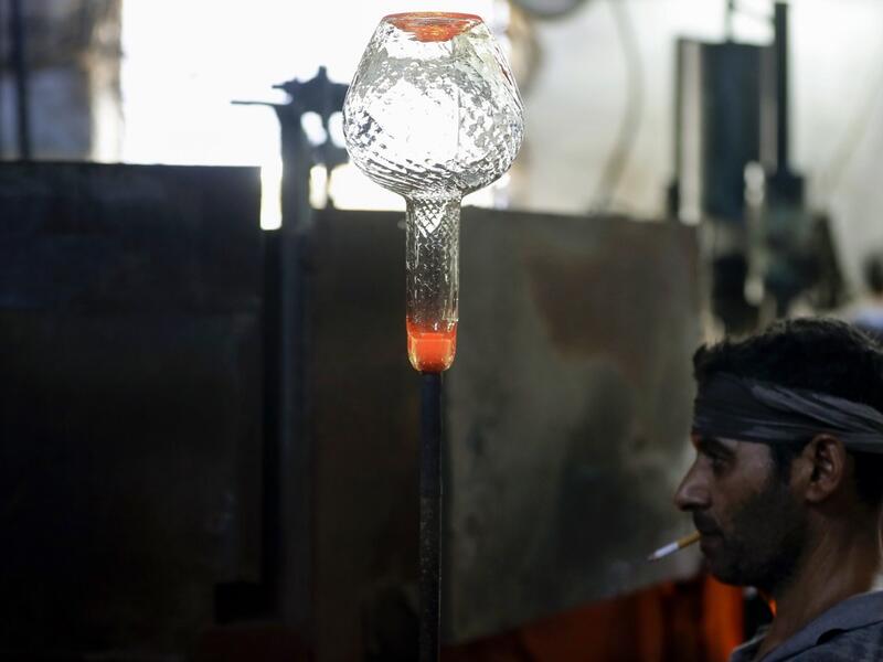 A glassblower forms glass at factory, which is recycling the broken glass as a result of the Beirut explosion, in the northern Lebanese port city of Tripoli on August 25, 2020. The August 4 port explosion ripped through countless glass doors and windows when it laid waste to whole Beirut neighbourhoods, killing at least 190 people and wounding thousands more. Volunteers, non-governmental groups and entrepreneurs salvaged a fraction of the tonnes of broken glass that littered the streets, some of it through 