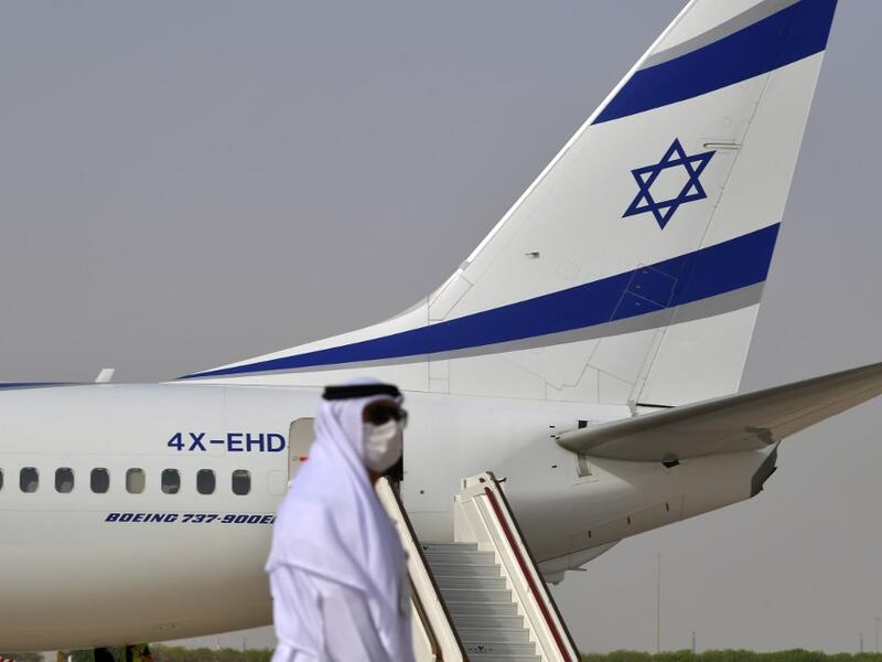 An Emirati official stands near an air-plane of El Al, which carried a US-Israeli delegation to the UAE following a normalisation accord, upon it's arrival at the Abu Dhabi airport in the first-ever commercial flight from Israel to the UAE, on August 31, 2020. KARIM SAHIB / AFP
