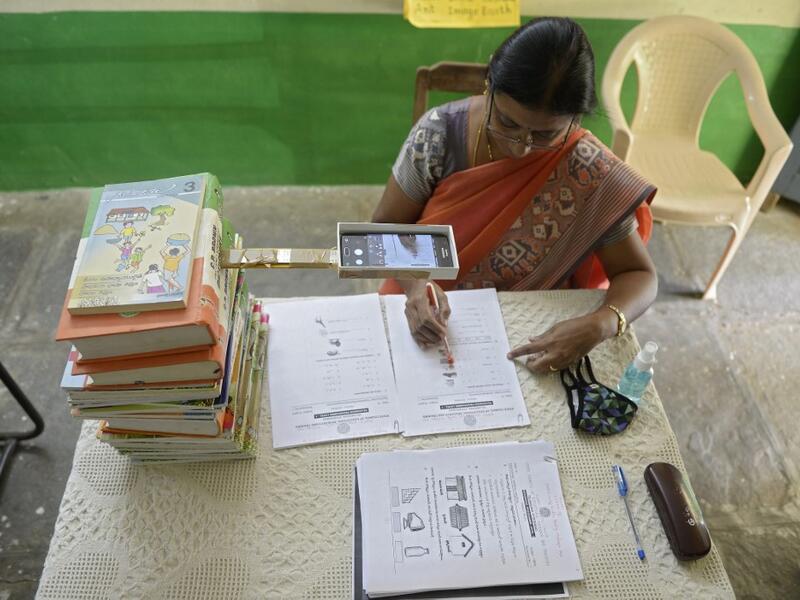 Headmistress M.C. Vijaya records worksheets on her mobile phone for the e-education classes at a government primary school in Nagireddypally Village of Siddipet District, some 50 kms from Hyderabad on September 1, 2020. AFP