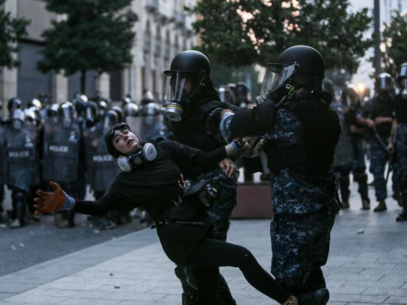 Lebanese riot police restrain a protester during an anti-government demonstration in central Beirut on September 01, 2020. AFP