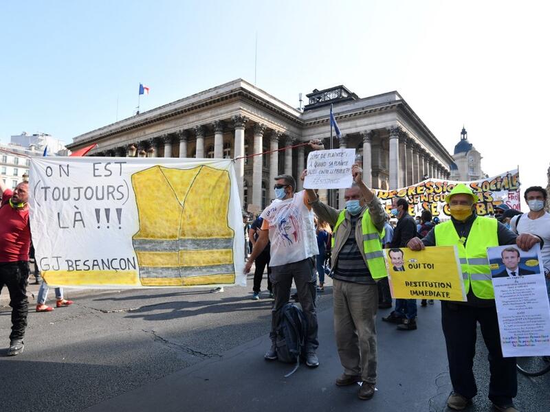 Protesters wearing protectice face masks holds placards and banners during a demonstration called by the "yellow vest" (gilets jaunes) movement on September 12, 2020 in Paris. Alain JOCARD / AFP