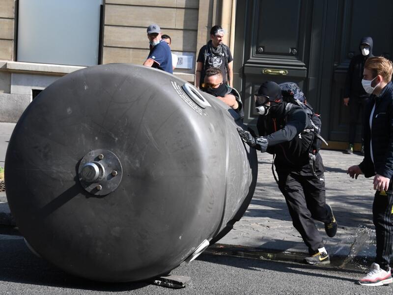 Protesters takes cover after police fired flee tear gas during a demonstration called by the "yellow vest" (gilets jaunes) movement on September 12, 2020 in Paris. Alain JOCARD / AFP