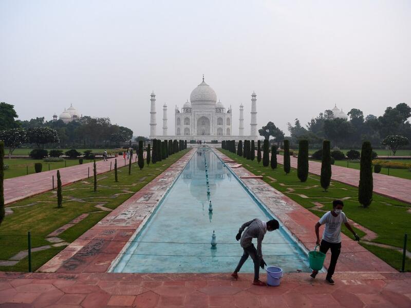 Workers clean the ground at the Taj Mahal in Agra on September 21, 2020. The Taj Mahal reopened to visitors on September 21 in a symbolic business-as-usual gesture even as India looks set to overtake the US as the global leader in coronavirus infections. Sajjad HUSSAIN / AFP