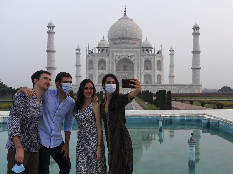 Tourists have their pictures taken at the Taj Mahal in Agra on September 21, 2020. The Taj Mahal reopened to visitors on September 21 in a symbolic business-as-usual gesture even as India looks set to overtake the US as the global leader in coronavirus infections. Sajjad HUSSAIN / AFP