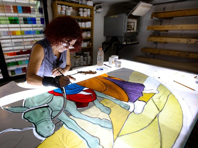 Lebanese stained glass artist Maya Husseini, 60, works on a piece for a cathedral under construction in Jordan, her main project before the Beirut port blast, in her basement workshop on the outskirts of the capital Beirut, on September 18, 2020. ANWAR AMRO / AFP
