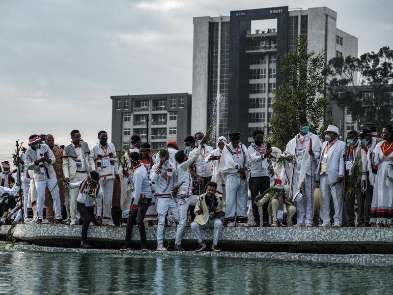 People spray water as part of the celebration of “Irreechaa”, the Oromo people thanksgiving holiday, in Addis Ababa, Ethiopia, on October 3, 2020. EDUARDO SOTERAS / AFP