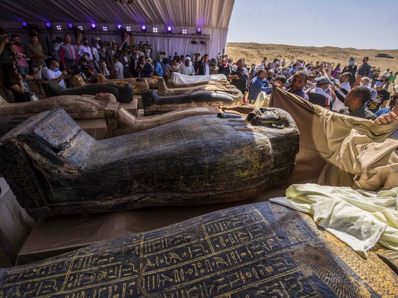 A picture taken on October 3, 2020 shows sarcophaguses, excavated by the Egyptian archaeological mission which discovered a deep burial well with more than 59 human coffins closed for more than 2,500 years, displayed during a press conference at the Saqqara necropolis, 30 kms south of the Egyptian capital Cairo. They were unearthed south of Cairo in the sprawling burial ground of Saqqara, the necropolis of the ancient Egyptian capital of Memphis, a UNESCO World Heritage site. Their exteriors are covered in 