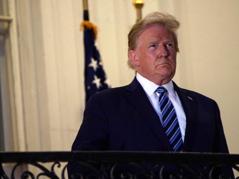 US President Donald Trump looks out from the Truman Balcony upon his return to the White House from Walter Reed Medical Center, where he underwent treatment for Covid-19, in Washington, DC, on October 5, 2020. NICHOLAS KAMM / AFP