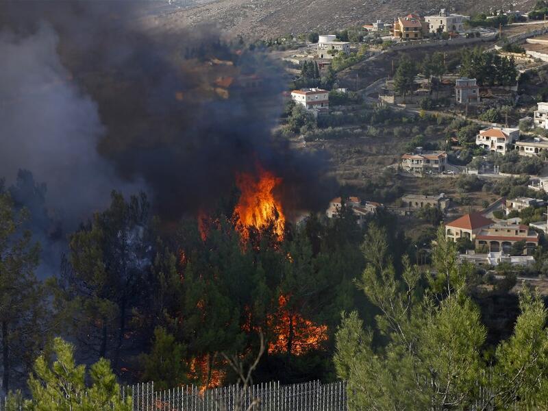 A picture taken near the northern Israeli kibbutz of Misgav Am in the Upper Galilee, shows a fire burning on the Lebanese side of the border with Israel on October 9, 2020. Several fires spread across northern and central Israel and the occupied West Bank as temperatures soared, forcing the evacuation of thousands of people, authorities said.  JALAA MAREY / AFP