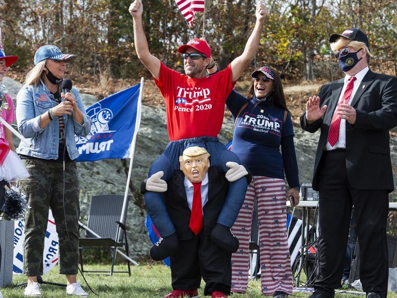 People dressed in political costumes participate in a contest during a Trump campaign rally named "Trumptoberfest" at Rocky Point Park in Warwick, Rhode Island on October 11, 2020. Many supporters dressed in political campaign clothing and waved flags while others dressed in festive costumes to take part in a political costume contest. Joseph Prezioso / AFP