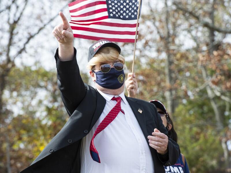 People dressed in political costumes participate in a contest during a Trump campaign rally named "Trumptoberfest" at Rocky Point Park in Warwick, Rhode Island on October 11, 2020. Many supporters dressed in political campaign clothing and waved flags while others dressed in festive costumes to take part in a political costume contest. Joseph Prezioso / AFP