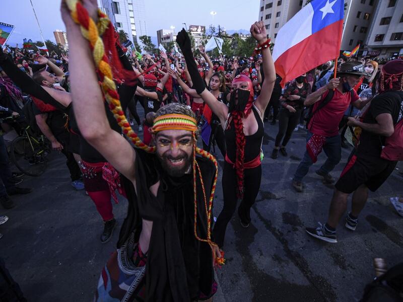 Demonstrators supporting the reform of the Chilean constitution gather waiting for the referendum official results at Plaza Italia square in Santiago on October 25, 2020. The campaign to replace Chile's dictatorship-era constitution held a big lead in Sunday's referendum, partial results showed. The "Approve" vote to throw-out a constitution seen as underpinning the nation's glaring inequalities led by 77.26 percent to 22.74 percent, with 11 percent of the votes counted.  MARTIN BERNETTI / AFP