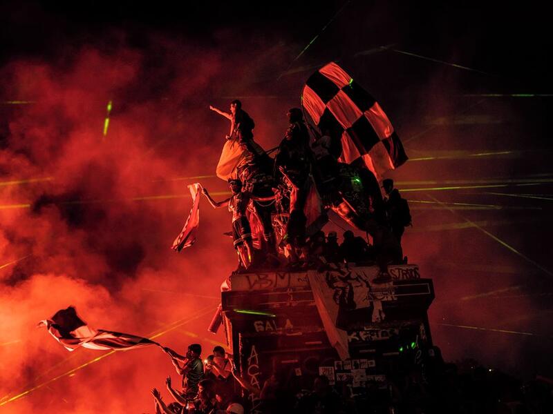 Demonstrators climb a statue in Plaza Baquedano on the night of 30 November 2019. Protesters, often together with football supporters, frequently gathered on Plaza Baquedano over weekends to chant and celebrate.⁣ ⁣ From ‘Chile: The Rebellion Against Neoliberalism’ by Fabio Bucciarelli (@fabio_bucciarelli) for L’Espresso (@espressosettimanale).⁣ (Instagram)