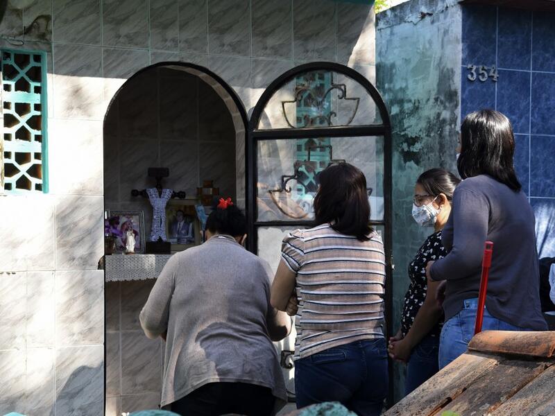 Women visit a relative's tomb at a cemetery in Asuncion on November 1, 2020, on All Saints' Day. Municipal cemeteries in Paraguay will be open to the public only on November 1 and 2, during All Saints' Day and the Day of the Dead, amid the new coronavirus pandemic. NORBERTO DUARTE / AFP
