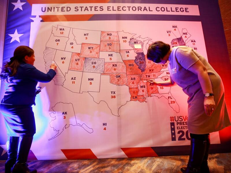 People colour in an electoral map during a US presidential election watch party at the US embassy in Ulaanbaatar, the capital of Mongolia on November 4, 2020. Byambasuren BYAMBA-OCHIR / AFP
