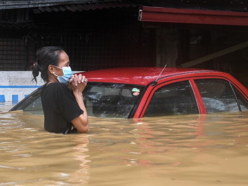 A resident makes her way through a flooded street to shelter after Typhoon Vamco hit, in Marikina City, suburban Manila on November 12, 2020. Ted ALJIBE / AFP