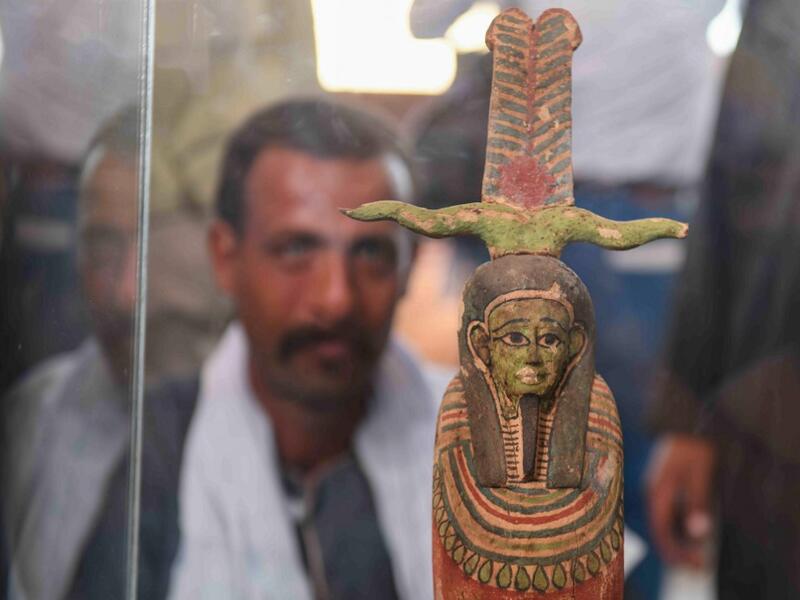 A picture shows a statue on display during the unveiling of an ancient treasure trove of more than a 100 intact sarcophagi, at the Saqqara necropolis 30 kms south of the Egyptian capital Cairo, on November 14, 2020. Egypt announced the discovery of an ancient treasure trove of more than a 100 intact sarcophagi, the largest such find this year. The sealed wooden coffins, unveiled on site amid fanfare, belonged to top officials of the Late Period and the Ptolemaic period of ancient Egypt. They were found in t