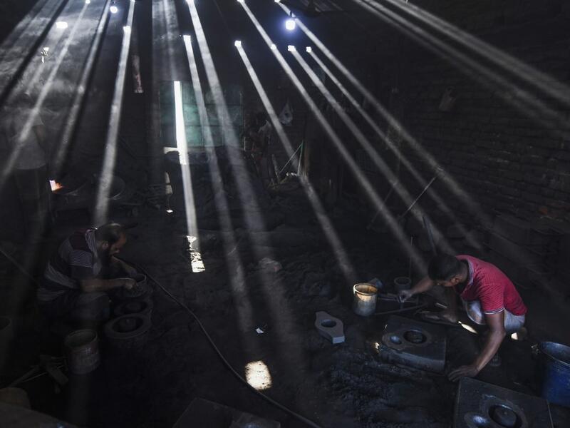 In this picture taken on November 16, 2020 dockyard workers prepare molds to make propeller at a workshop on the banks of the Buriganga river in Char Kaliganj on the outskirts of Dhaka. Rivers are the lifeblood of the delta nation of 168 million people where much of the low-lying land is accessed via boat, with Bangladesh's strong economic growth of recent years fuelling more investments in new and bigger ships. Munir UZ ZAMAN / AFP
