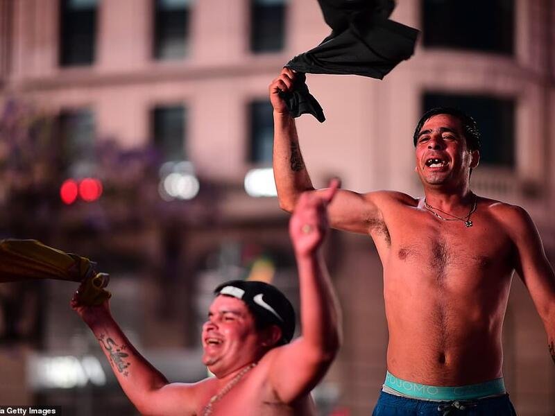 Fans wave their shirts in tribute to Maradona last night as they gathered by the Obelisk in the Argentinian capital. (AFP/File)