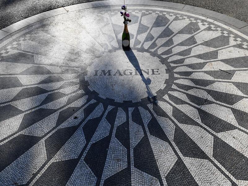 A champagne bottle with flowers adorns the "Imagine" mosaic at the Strawberry Fields Memorial for John Lennon, in Central Park on December 3, 2020 in New York City. On December 8, 1980, the filigree gates of New York's Dakota residence across from Central Park went down in history as the spot John Lennon was shot dead. But for nearly a decade prior to his shock murder, the former Beatle's adopted hometown was where he rediscovered life. Angela Weiss / AFP