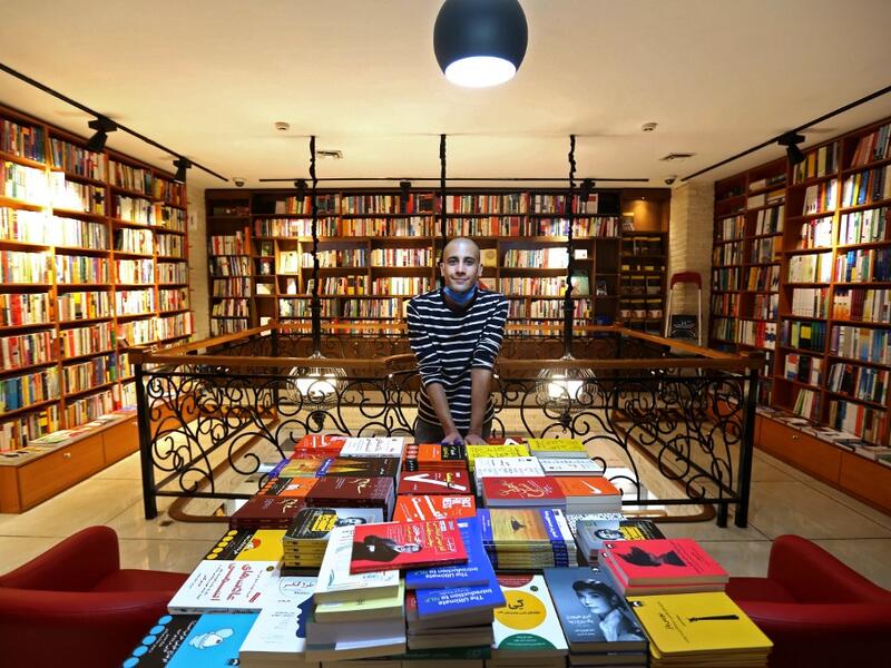An Iranian employee poses for a picture at a bookstore in Tehran's Enqelab (Revolution) street, on September 8, 2020. ATTA KENARE / AFP