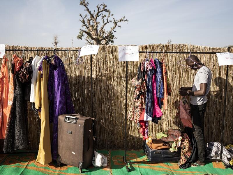 A designer unpacks his collection ahead of the start of Dakar Fashion Week in Dakar on December 12, 2020. JOHN WESSELS / AFP
