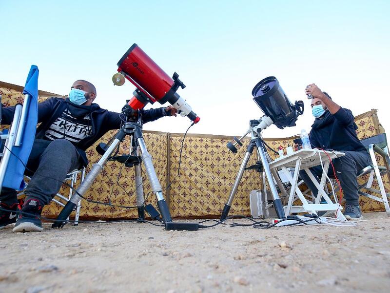 Kuwaiti astrophotographers Mohammad al-Obaidi (R) and Abdullah al-Harbi follow the great conjunction between Jupiter and Saturn in al-Salmi district, a desert area 120 kms west of Kuwait City, on December 21, 2020. The great conjunction refers to the alignment of Jupiter and Saturn. YASSER AL-ZAYYAT / AFP
